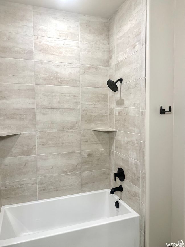 Basement bathroom with floor to ceiling tile shower and oversized bathtub | Image 33