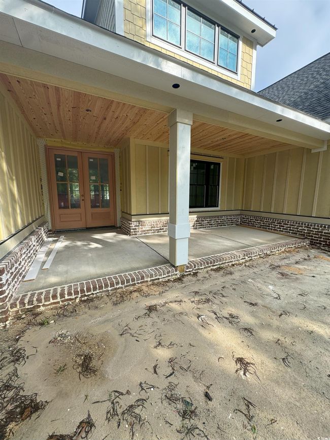 Entrance to property with board and batten siding, french doors, and roof with shingles | Image 17