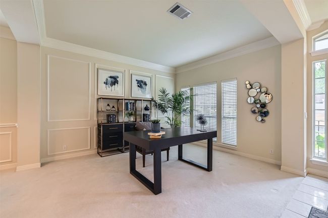 Front living currently being used as an office with 2 step crown molding, chair rail and front windows bringing in natural light | Image 9