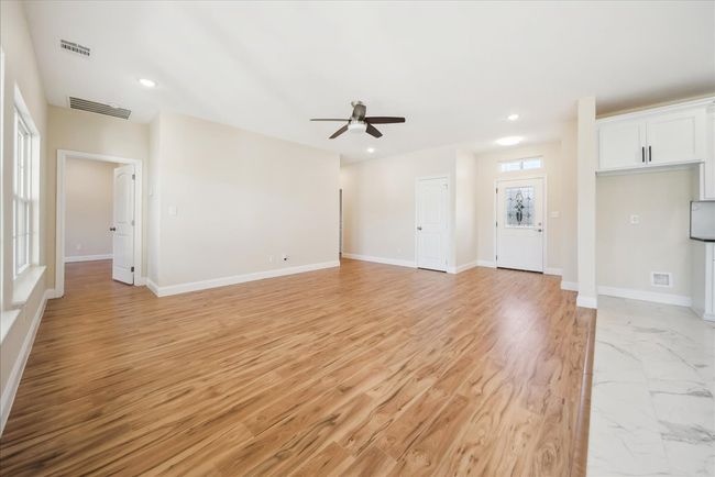Unfurnished living room featuring light wood-type flooring and ceiling fan | Image 4