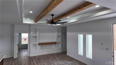 Unfurnished living room with ceiling fan, beam ceiling, and dark hardwood / wood-style floors | Image 2