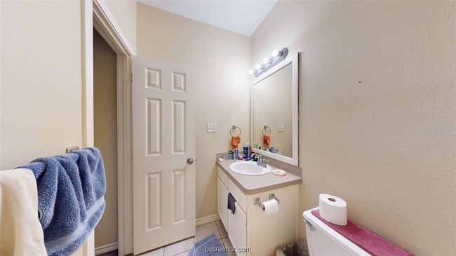 Bathroom with toilet, tile patterned flooring, and vanity | Image 14