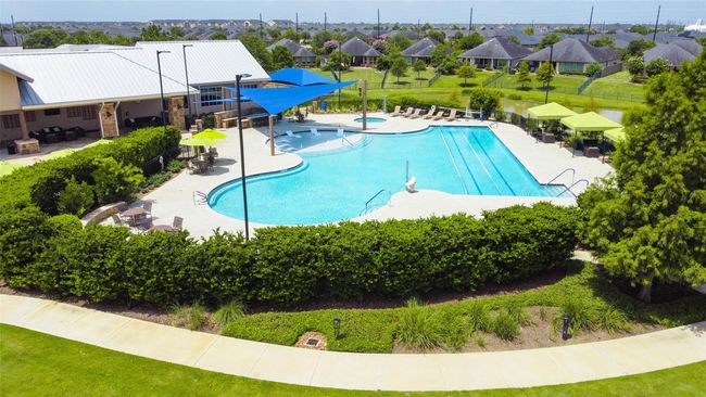Soak up the sun at the luxurious community pool, featuring dedicated lap lanes, a spacious lounge area, and a shaded sun shelf—perfect for relaxing right in the water. | Image 30