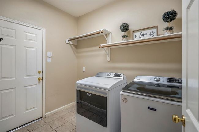 Back downstairs, the laundry room offers ample space, including a designated area for a fridge, adding extra convenience for household storage. | Image 32