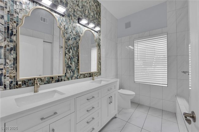 Bathroom featuring tile walls and double vanity | Image 21