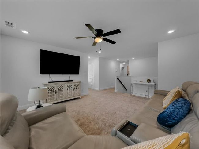 Carpeted living area featuring a ceiling fan, recessed lighting, and baseboards | Image 14