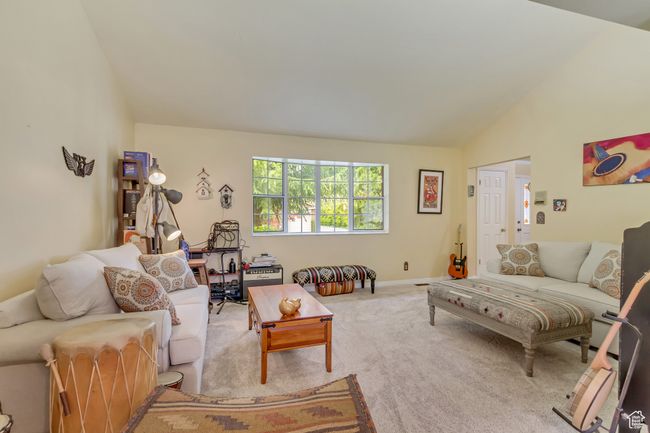 Living area with vaulted ceiling, baseboards, and carpet floors | Image 23
