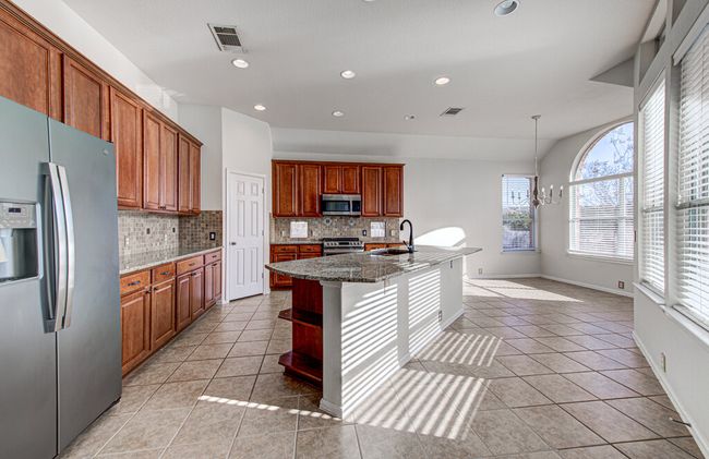 Kitchen with light tile patterned floors, visible vents, appliances with stainless steel finishes, and a sink | Image 13