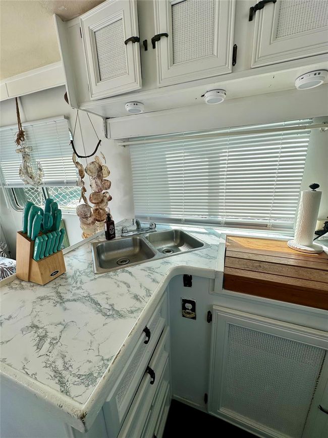 Kitchen featuring a sink, light countertops, and white cabinetry | Image 11