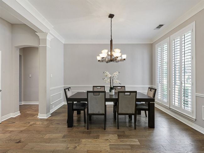 Dining space featuring arched walkways, plenty of natural light, dark wood-style flooring, and ornamental molding | Image 12
