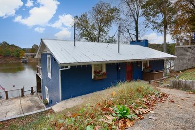 Front of house- covered front entry, metal roof, concrete driveway | Image 1