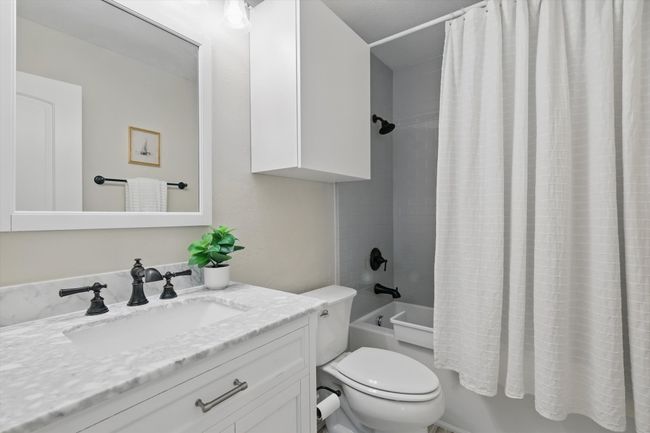 Bathroom featuring vanity and shower / bath combination with curtain | Image 23