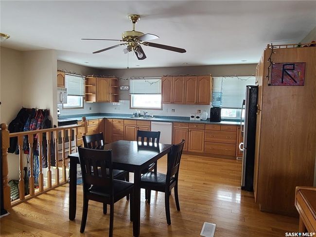Kitchen featuring light wood-type flooring, sink, ceiling fan, and stainless steel appliances | Image 7