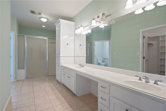 Full bath featuring a shower stall, double vanity, and tile patterned floors | Image 19