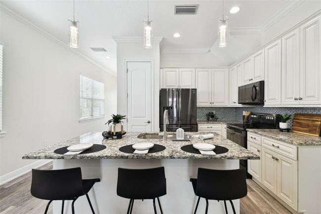 Large center island with ample cabinet and counter top space | Image 7