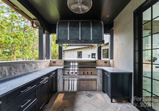 Covered Grilling patio with solid stone countertops and plenty of storage featuring a Wolf grill. | Image 15