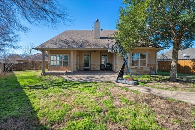 Back of property featuring a fenced backyard, a ceiling fan, stucco siding, and stone siding | Image 28