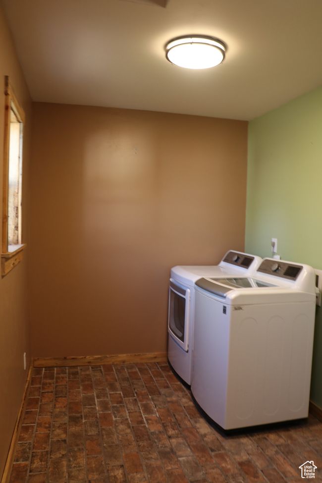 Laundry room featuring washer and dryer and brick floors | Image 17