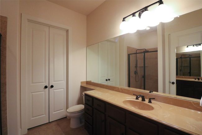 Full bathroom with a shower stall, tile patterned floors, vanity, and toilet | Image 25