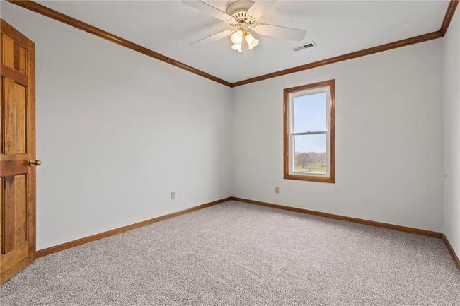 Carpeted empty room with crown molding and ceiling fan | Image 32