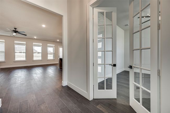 Corridor featuring dark wood-type flooring, visible vents, baseboards, and french doors | Image 29