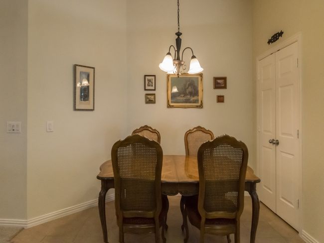 Casual dining area/breakfast nook features chandelier and a view of the spacious kitchen pantry with double doors. | Image 13