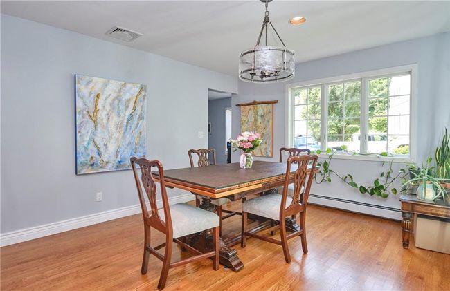 Dining space featuring light hardwood / wood-style flooring, an inviting chandelier, and a baseboard heating unit | Image 19