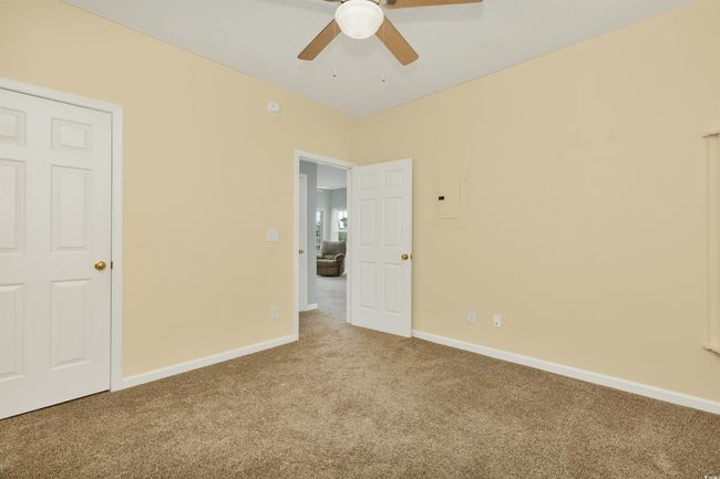 Unfurnished bedroom featuring carpet flooring, baseboards, a ceiling fan, and electric panel | Image 17