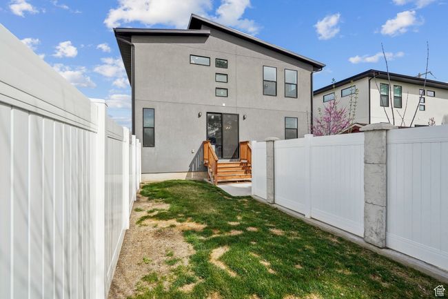 Rear view of property featuring stucco siding and fence | Image 37