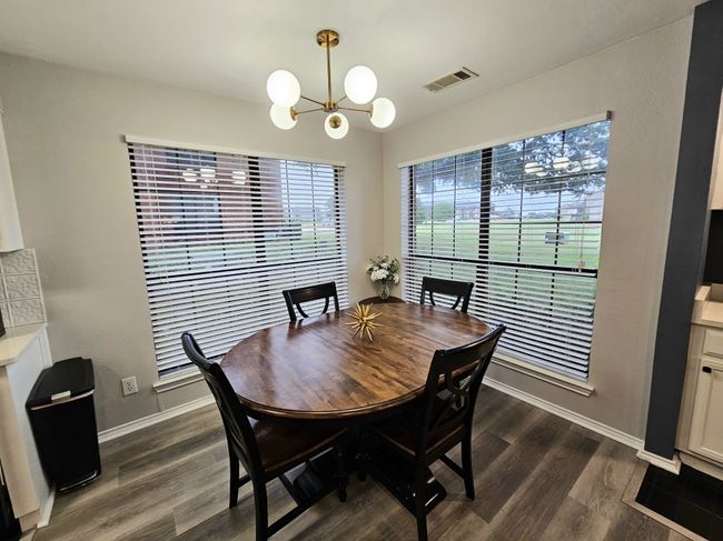 Dining room featuring a chandelier, dark wood-style flooring, and baseboards | Image 5