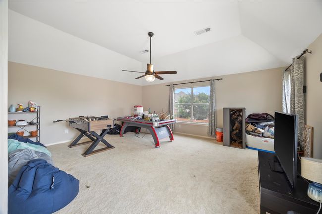 Playroom with carpet floors, vaulted ceiling, a ceiling fan, and baseboards | Image 23