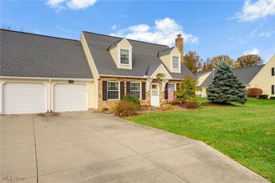 New england style home with a front lawn and a garage | Image 1