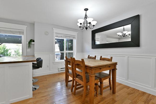 Dining space featuring a chandelier, a decorative wall, light wood-style floors, and a wainscoted wall | Image 17