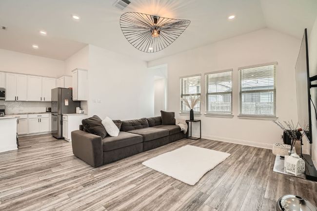 Living room featuring light wood-style floors, recessed lighting, and vaulted ceiling | Image 9
