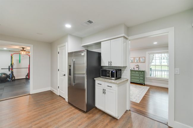 Kitchen featuring appliances with stainless steel finishes, light wood-type flooring, white cabinets, and visible vents | Image 12