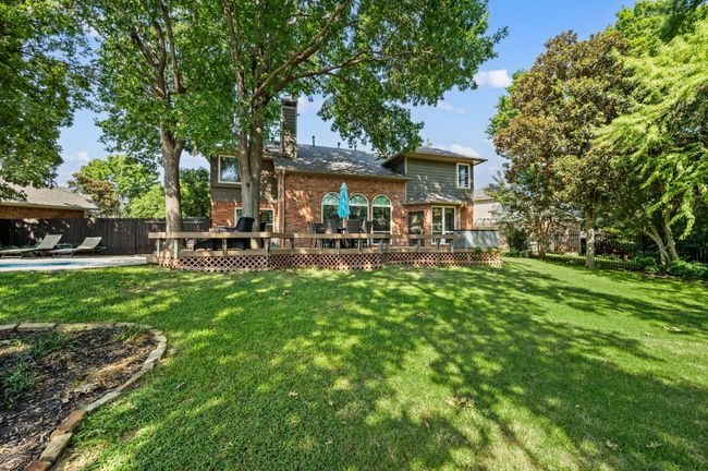 Back of property featuring brick siding, a deck, and a chimney | Image 33