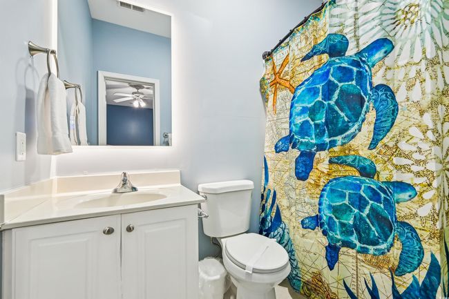 Bathroom with vanity, a shower with shower curtain, and a ceiling fan | Image 12
