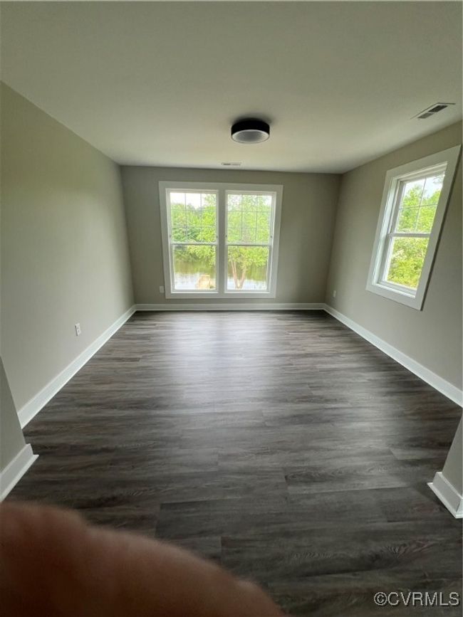 Empty room with baseboards, dark wood finished floors, and visible vents | Image 18