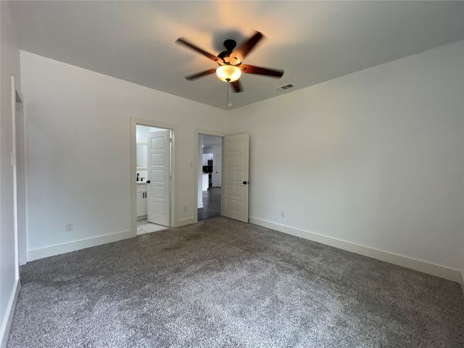 Unfurnished bedroom with carpet, baseboards, ensuite bathroom, and ceiling fan | Image 25