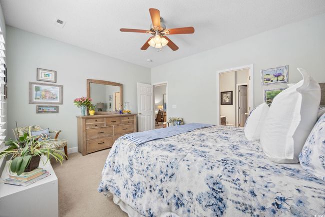 Bedroom with light carpet and a ceiling fan | Image 17