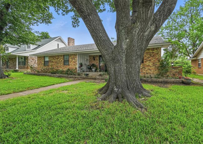 View of front of home with a chimney, brick siding, a front yard, and a shingled roof | Image 4