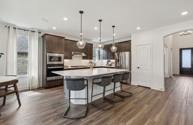 Spacious eat-in kitchen designed with a large island for dining *Model representation | Image 5
