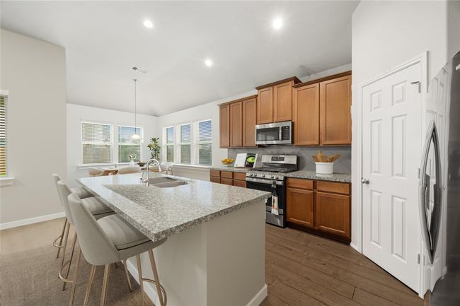 The heart of the home shines with granite countertops, a generous island perfect for entertaining, and stylish cabinetry throughout. *Virtually Staged | Image 9