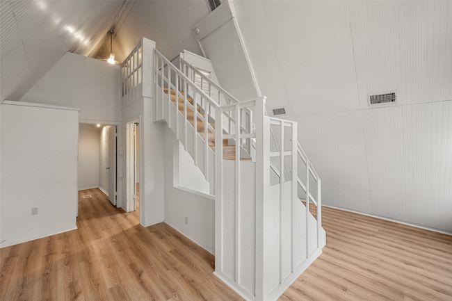 Staircase with laminate floors and a towering ceiling | Image 23