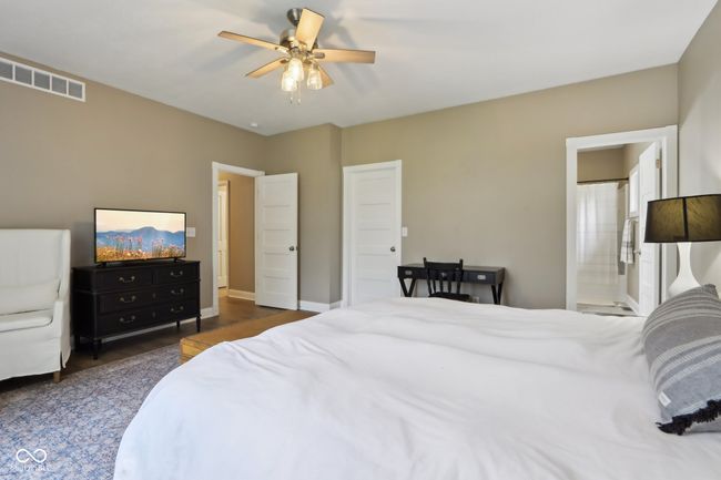 bedroom with baseboards, connected bathroom, visible vents, and a ceiling fan | Image 33
