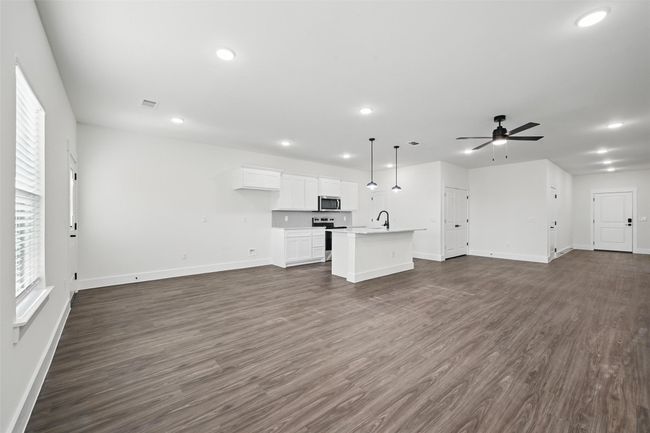 Unfurnished living room with recessed lighting, baseboards, dark wood finished floors, a sink, and ceiling fan | Image 6