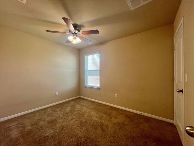 bed room with dark colored carpet, a ceiling fan, and baseboards | Image 9