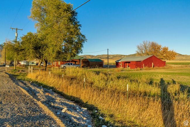 View of yard featuring a rural view and a view of the shop building | Image 6