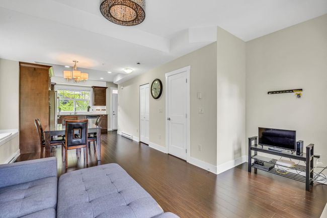 Living room featuring a chandelier, dark wood-style floors, and baseboards | Image 4