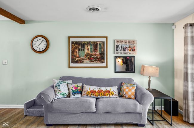 living room with wood finished floors, visible vents, and baseboards | Image 15